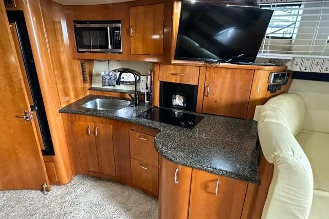 Slide: The Image of 2004 Carver 360 Mariner interior with kitchenette, microwave, sink, and TV. - 26