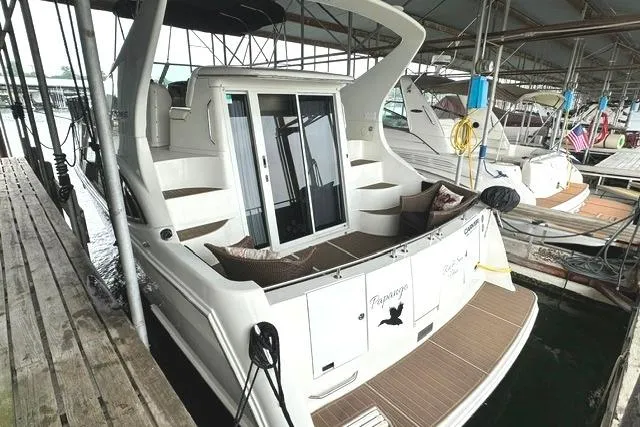 Slide: The Image of 2004 Carver 360 Mariner docked, featuring spacious deck and sliding glass doors. - 3