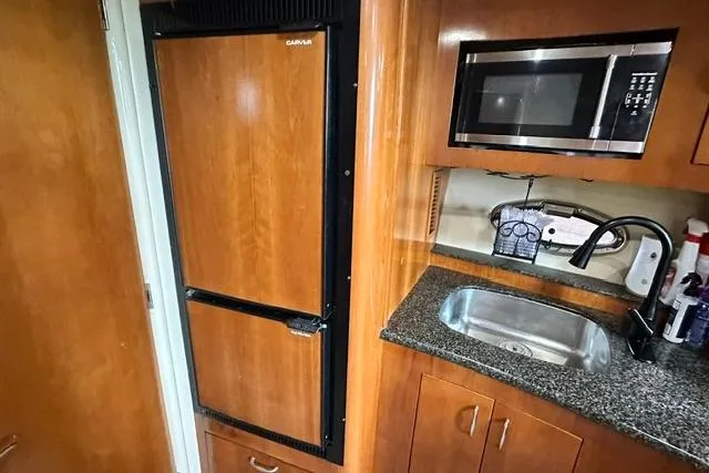 Slide: The Image of Kitchen area in a 2004 Carver 360 Mariner with fridge, microwave, and sink. - 31