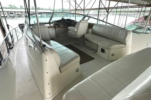 Slide: The Image of 2004 Carver 360 Mariner interior with spacious seating and helm, docked in a marina. - 9