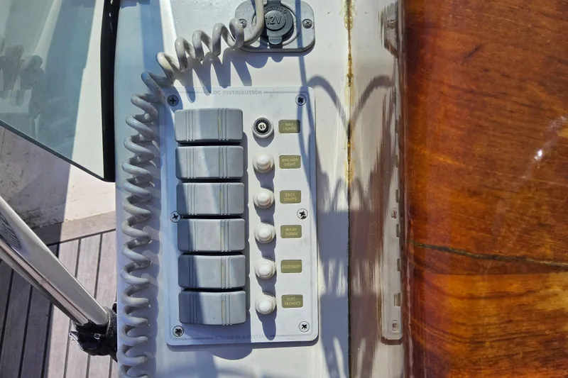 Slide: The Image of Control panel on a 2010 Grey Barn Boatworks North Shore 22, featuring labeled switches and buttons. - 15