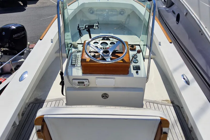 Slide: The Image of Cockpit of 2010 Grey Barn Boatworks North Shore 22 with steering wheel and controls. - 17