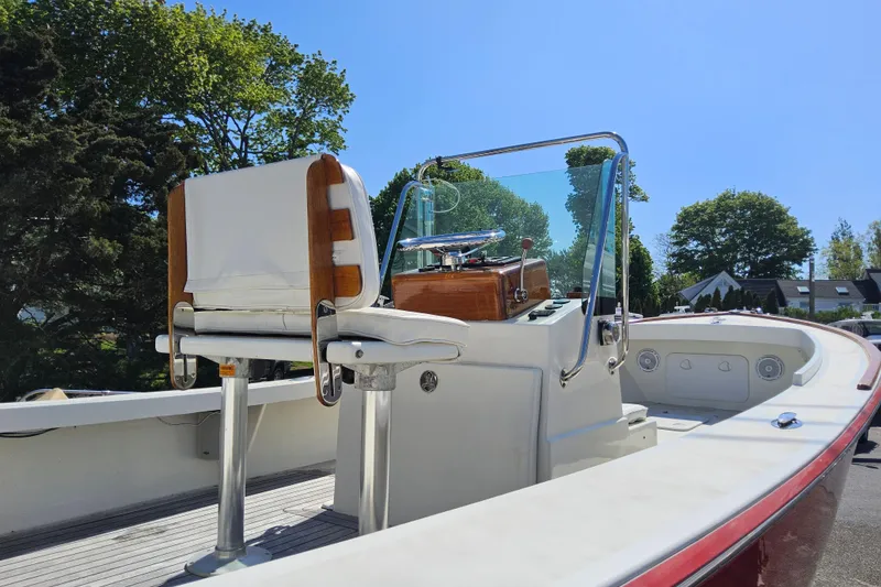 Slide: The Image of 2010 Grey Barn Boatworks North Shore 22 with sleek console and seating, under clear blue sky. - 18