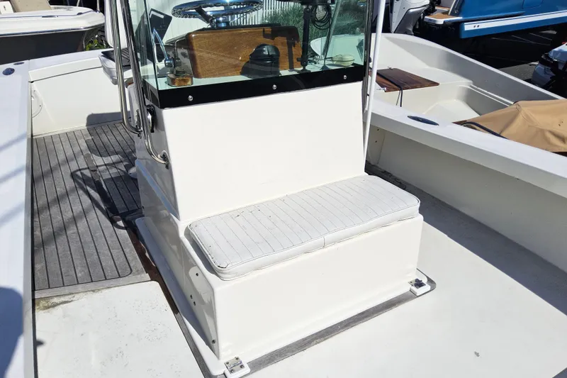 Slide: The Image of 2010 Grey Barn Boatworks North Shore 22 interior with cushioned seating and steering console. - 8
