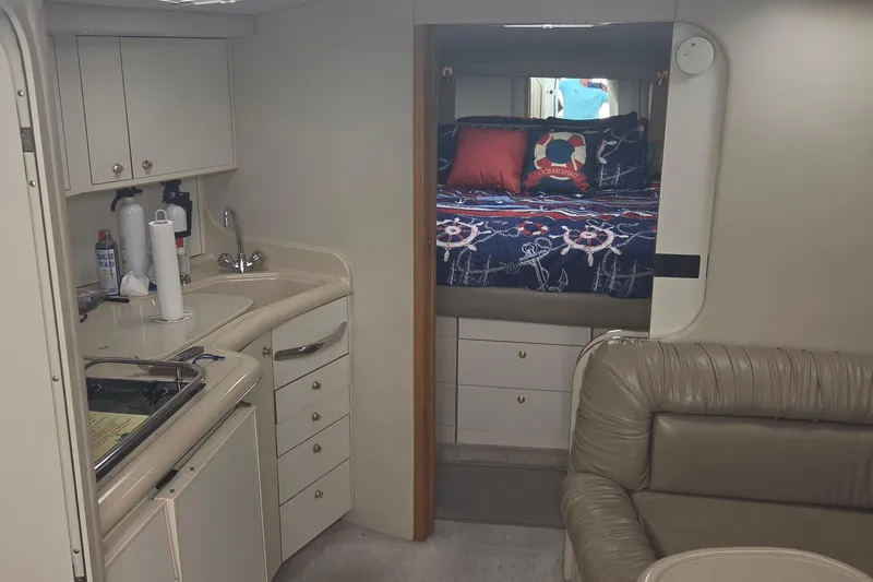 Slide: The Image of Interior of 1998 Sea Ray 370 Express Cruiser with kitchenette and cozy sleeping area. - 20