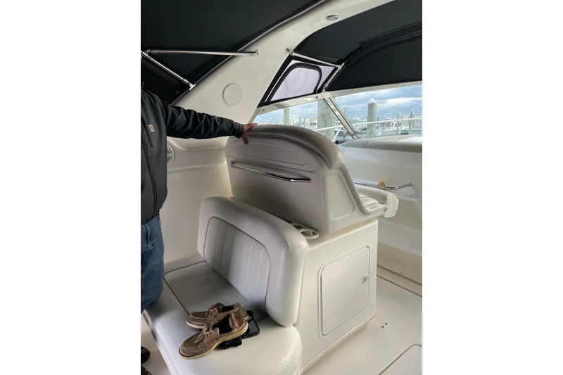 Slide: The Image of 1998 Sea Ray 370 Express Cruiser interior with white seating and shoes on the bench. - 5