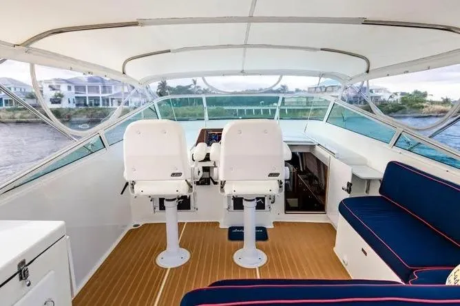 Slide: The Image of 2000 Pacific Mariner 65 Motoryacht helm with white seats and blue cushioned seating. - 3