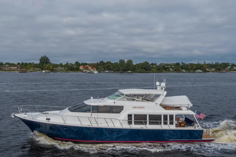 Slide: The Image of 2000 Pacific Mariner 65 Motoryacht cruising on a calm waterway under cloudy skies. - 31