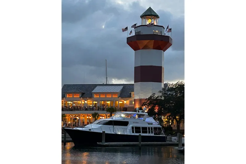 Slide: The Image of Pacific Mariner 65 Motoryacht docked near a lighthouse at dusk, 2000 model. - 71