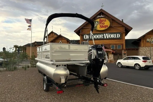Slide: The Image of 2026 Sun Tracker Party Barge 16 DLX pontoon boat outside Bass Pro Shops. - 1