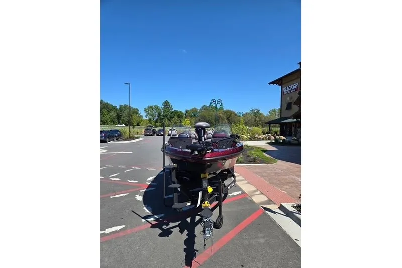 Slide: The Image of 2026 Nitro ZV20 boat parked outdoors on a sunny day near a store. - 2