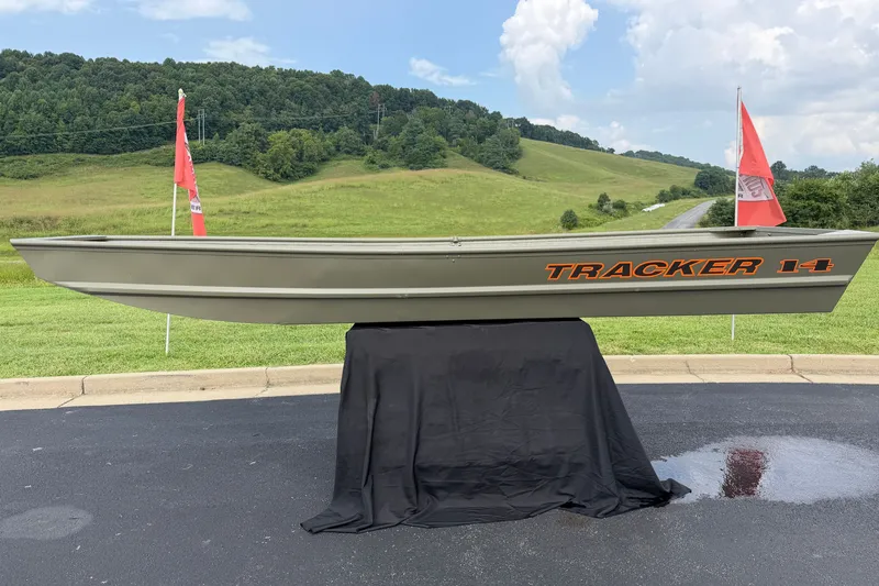 The Image of 2026 Tracker Grizzly 14 Jon boat displayed outdoors with scenic green hills. - 0