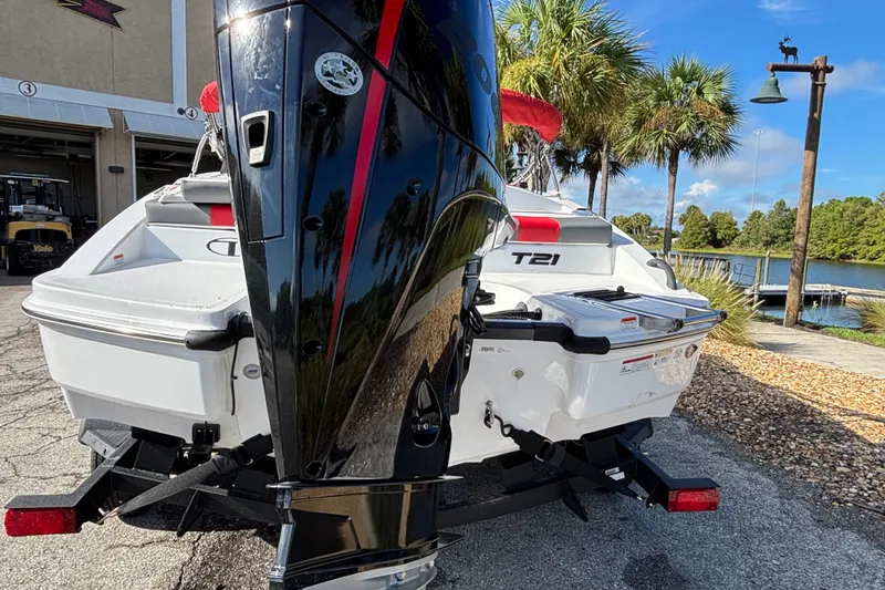 Slide: The Image of 2026 Tahoe T21 boat with outboard motor, parked near a scenic lakeside. - 3