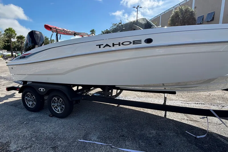 Slide: The Image of 2026 Tahoe T21 boat on trailer, parked outdoors under a clear blue sky. - 1
