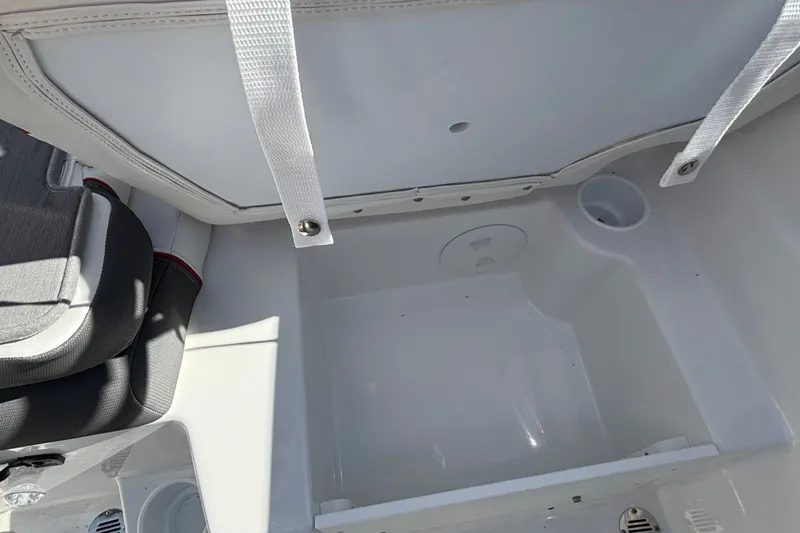 Slide: The Image of 2026 Tahoe T21 boat storage compartment with white interior and cup holder. - 18