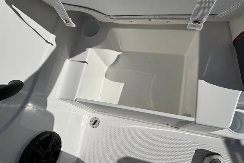 Slide: The Image of Interior compartment of 2026 Tahoe T21 boat, featuring storage space and cup holders. - 19