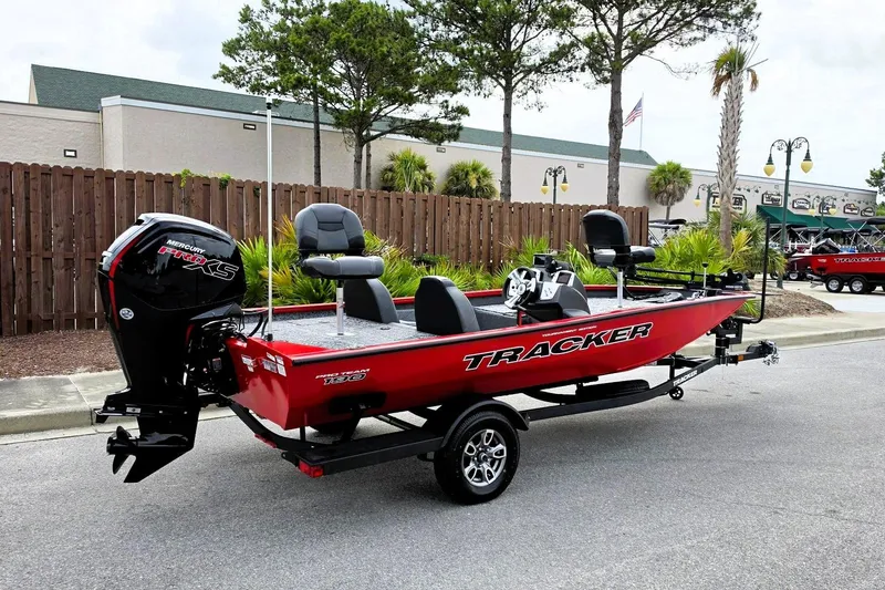 Slide: The Image of 2026 Tracker Pro Team 190 boat, red exterior, parked outdoors with Mercury Pro XS engine. - 2