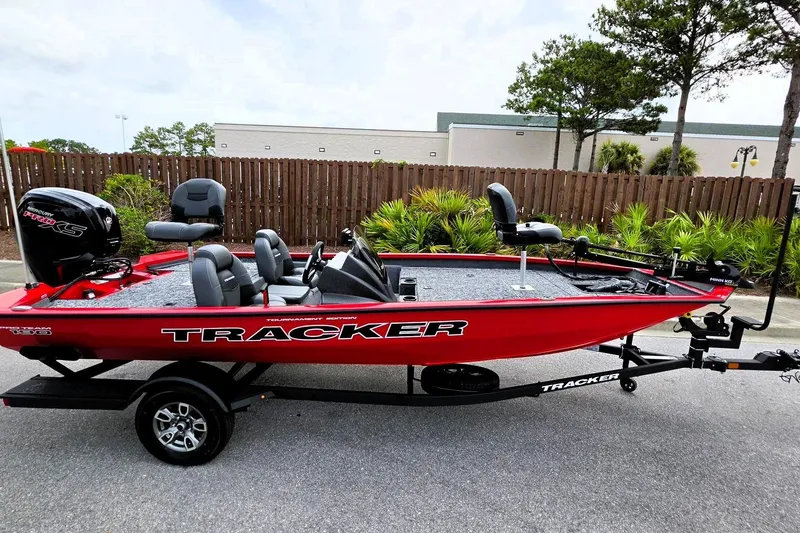 Slide: The Image of 2026 Tracker Pro Team 190 boat in vibrant red, parked outdoors on a trailer. - 8