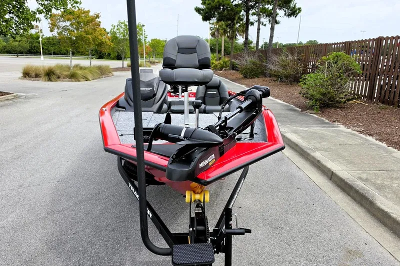 Slide: The Image of 2026 Tracker Pro Team 190 boat with red exterior, parked on a paved road. - 6