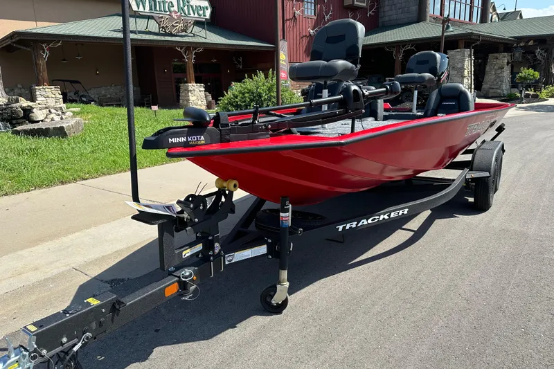 Slide: The Image of 2026 Tracker Pro Team 195 boat in red on a trailer, parked outside a shop. - 10