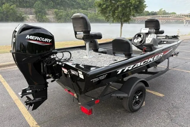 Slide: The Image of 2026 Tracker Pro Team 175 Crappie Edition boat with Mercury engine, parked by a scenic river. - 7