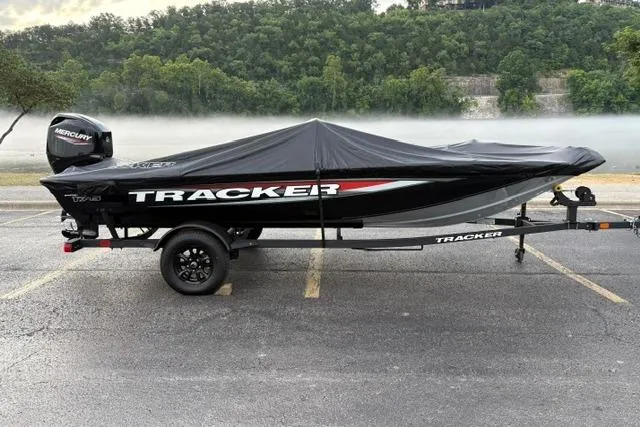 Slide: The Image of 2026 Tracker Pro Team 175 Crappie Edition boat with cover, parked on a lakeside road. - 12