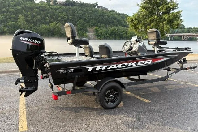 Slide: The Image of 2026 Tracker Pro Team 175 Crappie Edition boat with Mercury engine, parked near a scenic river. - 10