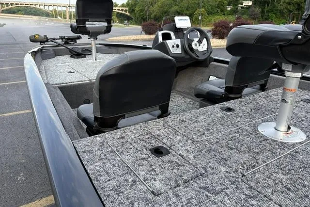 Slide: The Image of 2026 Tracker Pro Team 175 Crappie Edition boat with seating and control panel in a parking lot. - 18