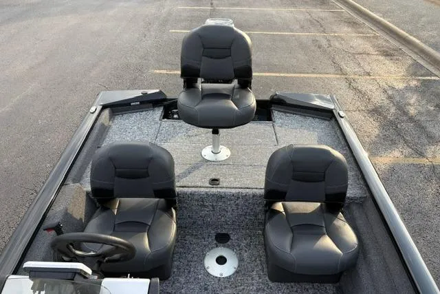 Slide: The Image of 2026 Tracker Pro Team 175 Crappie Edition boat with three black seats, parked on asphalt. - 16