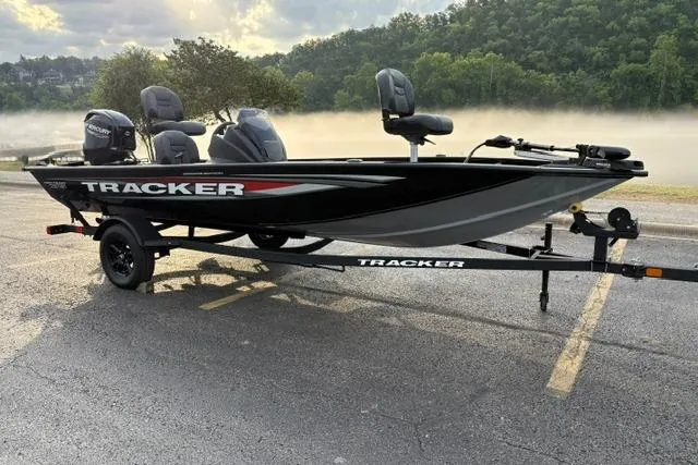 Slide: The Image of 2026 Tracker Pro Team 175 Crappie Edition boat on trailer, parked near misty lake. - 2
