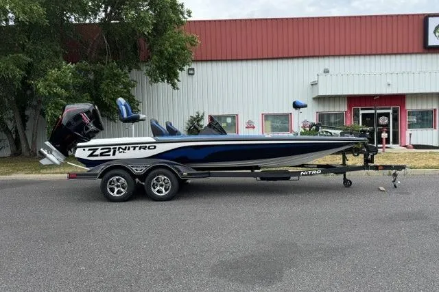 The Image of 2026 Nitro Z21 XL boat on trailer, parked outside a building. - 0