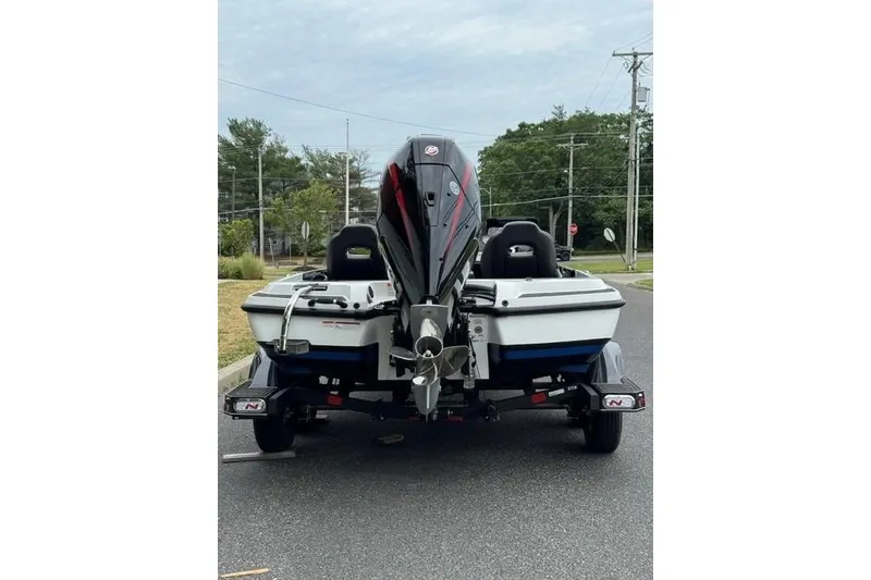 Slide: The Image of 2026 Nitro Z21 XL boat on trailer, rear view, parked on road. - 4