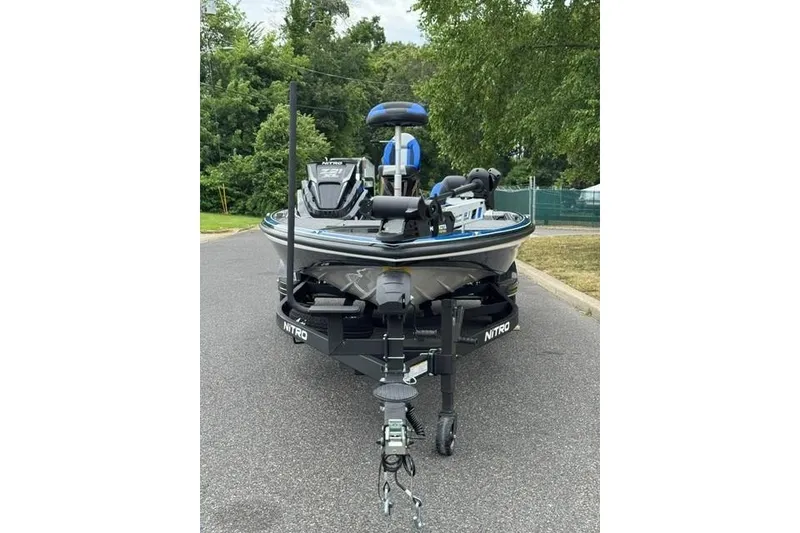 Slide: The Image of 2026 Nitro Z21 XL boat on trailer, parked on a road with trees in background. - 3