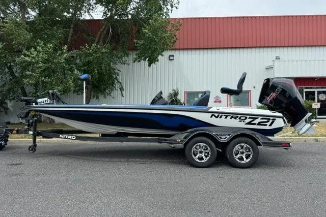 Slide: The Image of 2026 Nitro Z21 XL boat on trailer, parked outdoors near a building. - 1