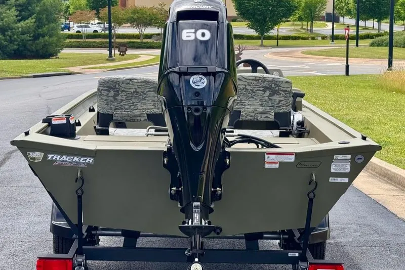 Slide: The Image of 2026 Tracker Grizzly 1754 SC boat with Mercury 60 engine, parked outdoors. - 5