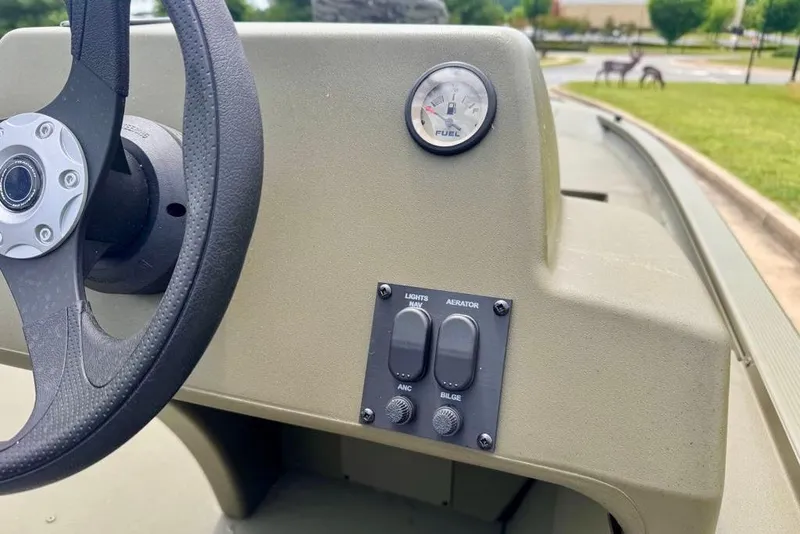 Slide: The Image of Steering console of 2026 Tracker Grizzly 1754 SC boat with fuel gauge and switches. - 12