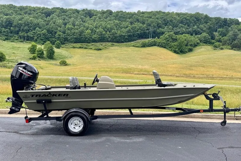 The Image of 2026 Tracker Grizzly 1754 SC boat on trailer, set against a scenic countryside backdrop. - 0