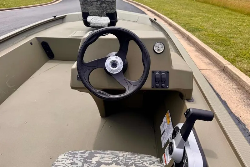 Slide: The Image of 2026 Tracker Grizzly 1754 SC boat interior with steering wheel and control panel. - 11