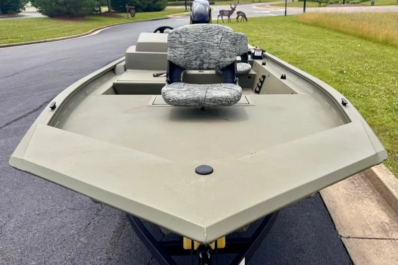Slide: The Image of 2026 Tracker Grizzly 1754 SC boat with camouflage seating on a paved road. - 4