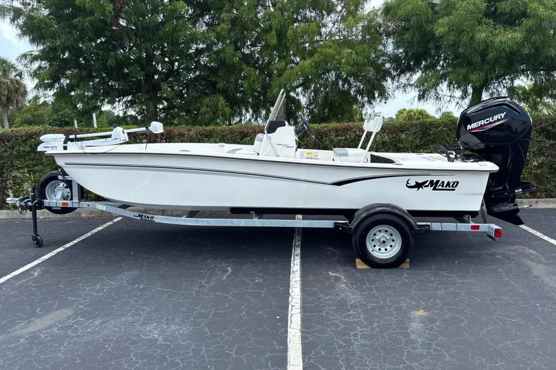 The Image of 2026 Mako Pro Skiff 17 CC boat on trailer, parked outdoors with Mercury engine. - 0