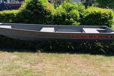 The Image of 2026 Tracker Grizzly 14 Jon boat on grass, surrounded by greenery. - 0