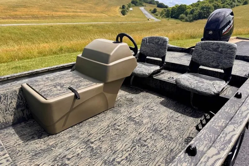 Slide: The Image of 2026 Tracker Grizzly 1754 SC boat interior with camo seats and steering console. - 9