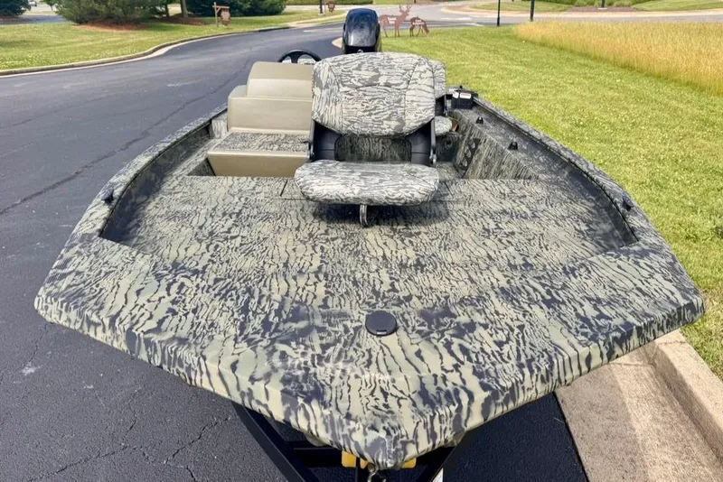Slide: The Image of 2026 Tracker Grizzly 1754 SC boat with camouflage design on a paved surface. - 5