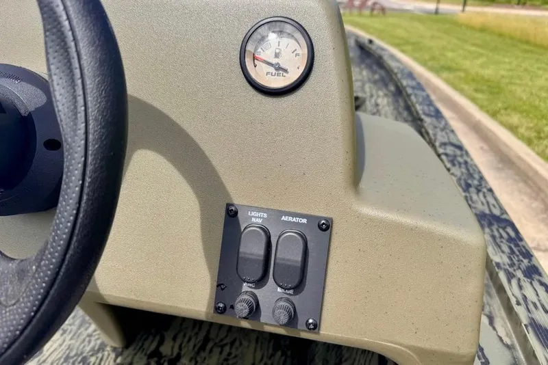 Slide: The Image of 2026 Tracker Grizzly 1754 SC dashboard with fuel gauge and control switches. - 12