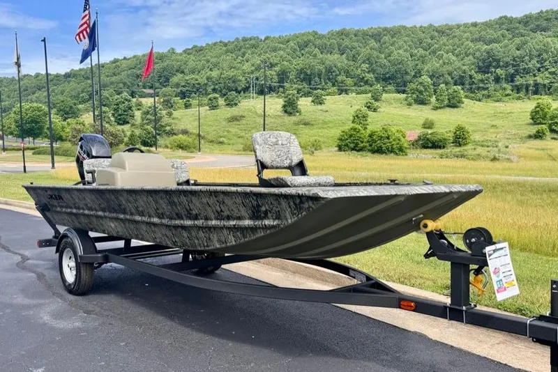 Slide: The Image of 2026 Tracker Grizzly 1754 SC boat on trailer, parked outdoors with scenic background. - 2