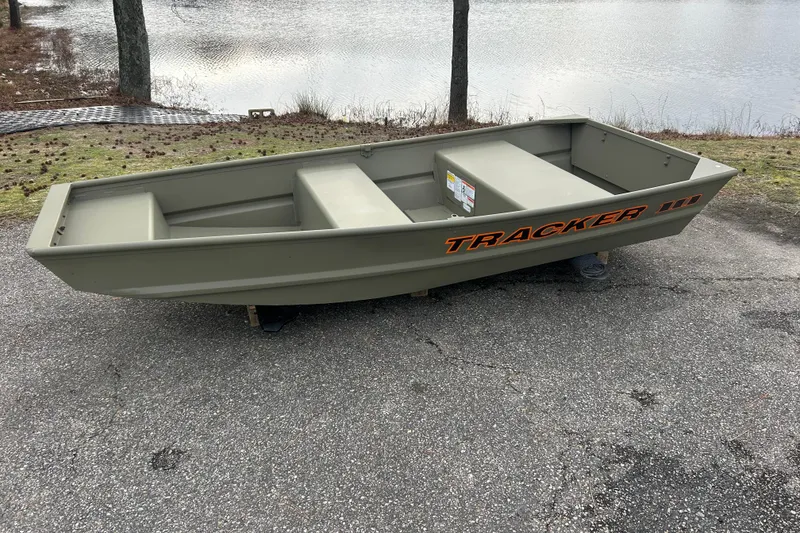 The Image of 2026 Tracker Grizzly 10 Jon boat on pavement near a lake. - 0