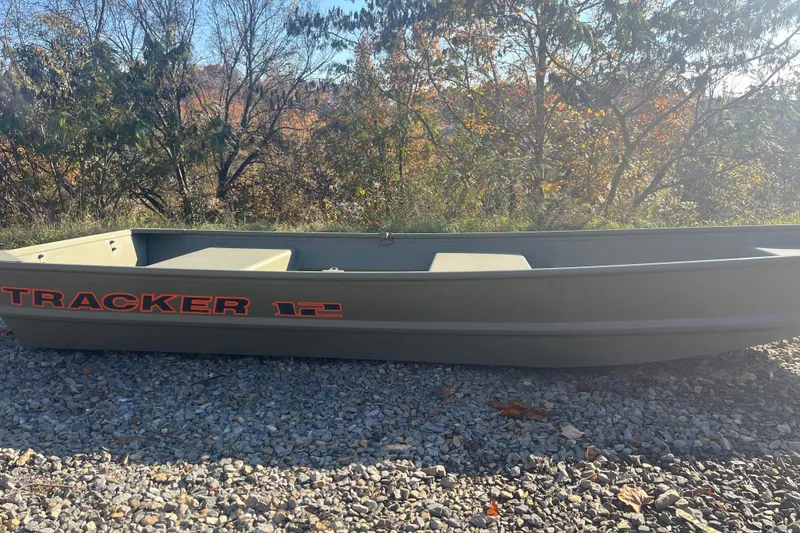 The Image of 2026 Tracker Grizzly 12 Jon boat on gravel, surrounded by autumn trees. - 0