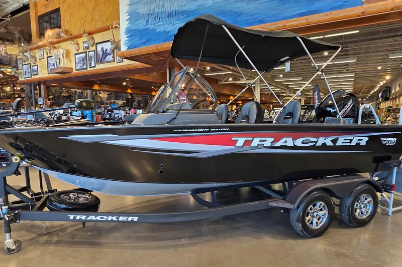 The Image of 2026 Tracker Targa V-18 Combo boat displayed indoors with sleek black design. - 0