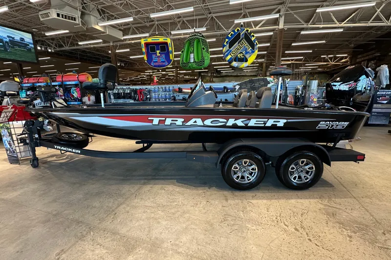 The Image of 2026 Tracker Savage 215 boat displayed in a showroom with accessories. - 0