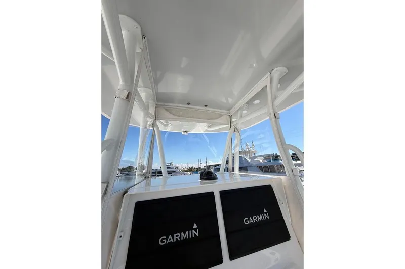 Slide: The Image of 2021 Contender boat interior with Garmin navigation system, showcasing sleek design and clear skies. - 13